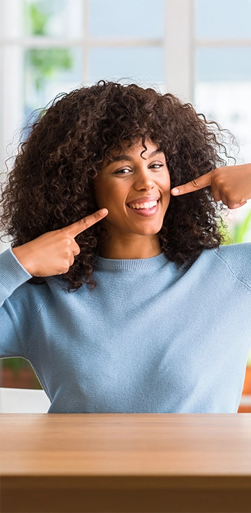 Lady In A Blue Sweater Pointing To Her Smile