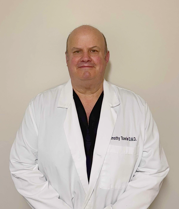Dentist Timothy Towle Smiling In Lab Coat